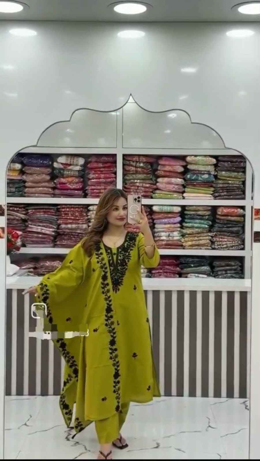 Front view of full three piece olive green flared cotton a line kurti set displaying an embroidered top straight pants and heavy dupatta.
