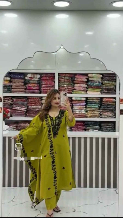 Front view of full three piece olive green flared cotton a line kurti set displaying an embroidered top straight pants and heavy dupatta.