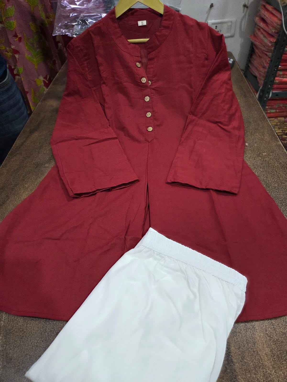 Close up view of the stylish button detailing and premium fabric weave lines on a rich maroon cotton ethnic tunic bodice.