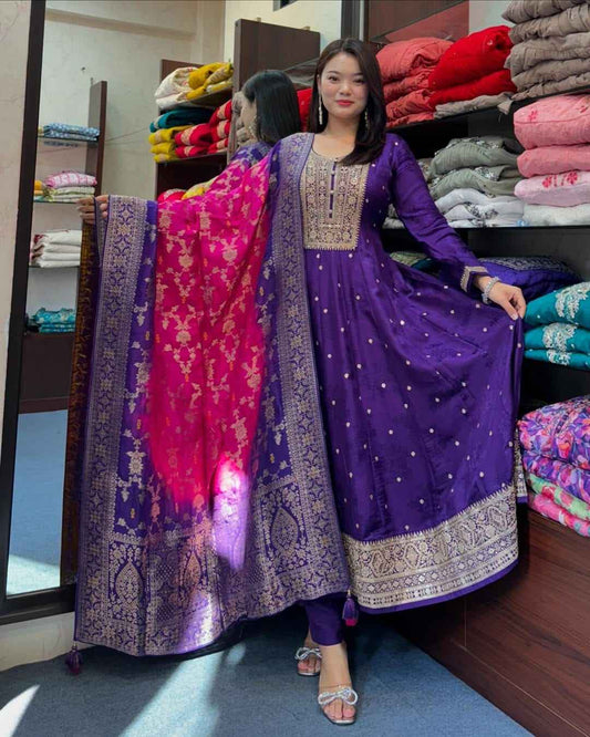 Front view of full three piece purple Anarkali flared silk kurti set displaying a long flared banana silk gown trousers and Banarasi dupatta.