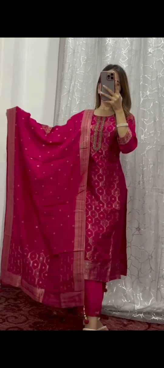 Front view of full three piece dark pink pure banarasi jacquard suit set displaying a woven zari tunic silk pants and a matching jacquard dupatta.