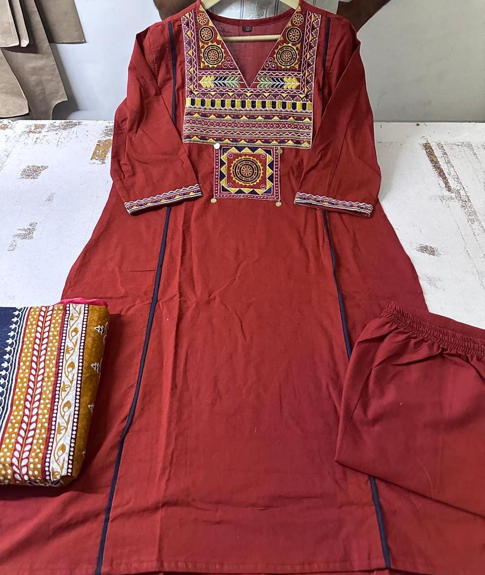 Close up view of detailed traditional thread embroidery work and intricate weaving patterns on a deep maroon pure cotton fabric yoke panel.