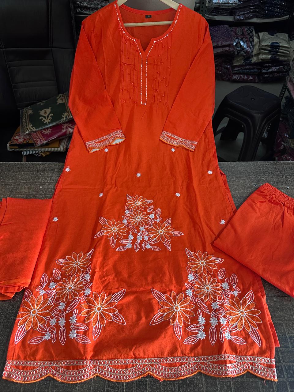 Close up view of detailed traditional embroidery work and high quality thread patterns on a vibrant orange heavy cotton fabric bodice canvas - WishTown Fashion Club