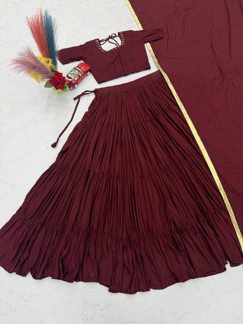 Close up view of detailed real handmade mirror work embroidery and fine stitching on maroon choli bodice panel - WishTown Fashion Club