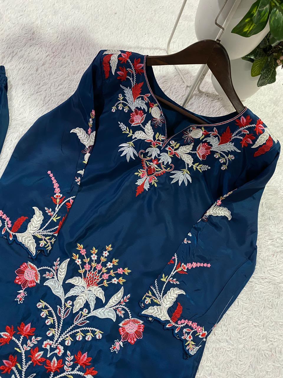Detailed view of embroidery pattern and cut work design along blue French crape palazzo hemline - WishTown Fashion Club