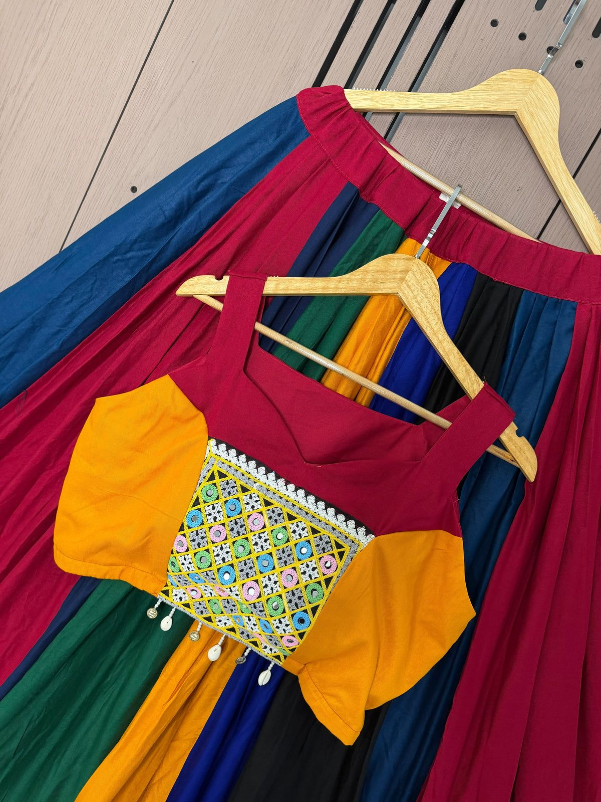 Flat lay display of complete multi colour lehenga set showing flared skirt and stitched mirror blouse - WishTown Fashion Club