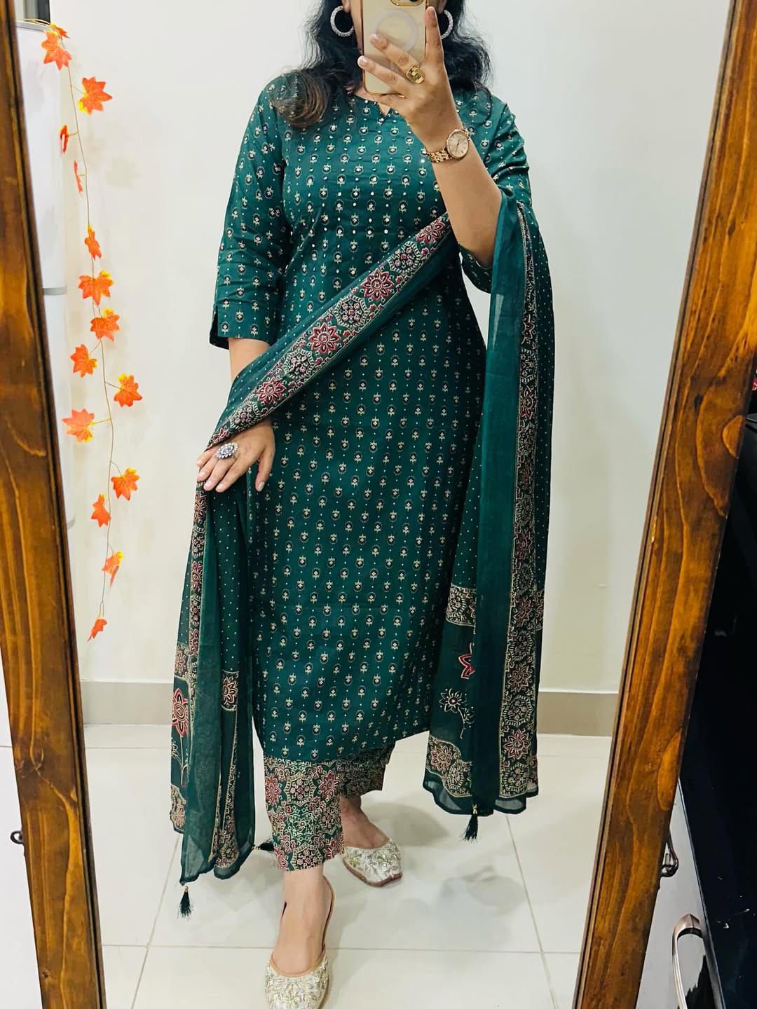 Close up view of intricate handcrafted needlework patterns and premium stitching details on high quality teal green cotton fabric.