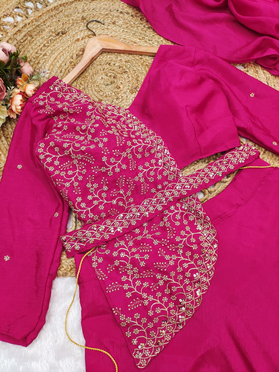 Side perspective highlighting the attached pleated drape dupatta scarf with a lace border flowing over a rani pink ethnic skirt.