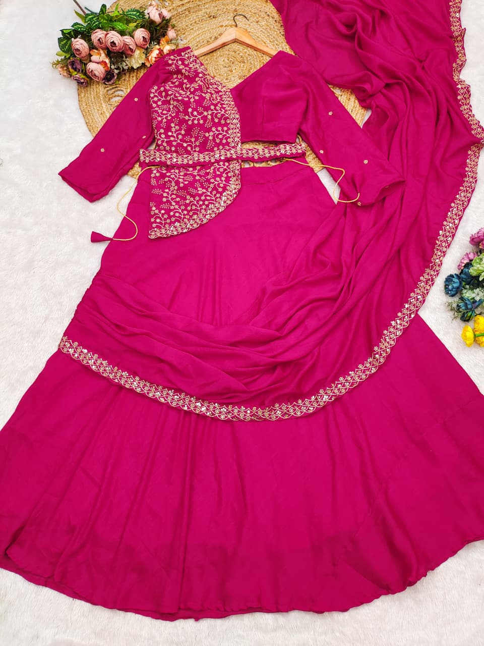 Close up view of detailed multi thread embroidery patterns and shimmering sequence highlighting on a bright rani pink chinnon silk bodice.