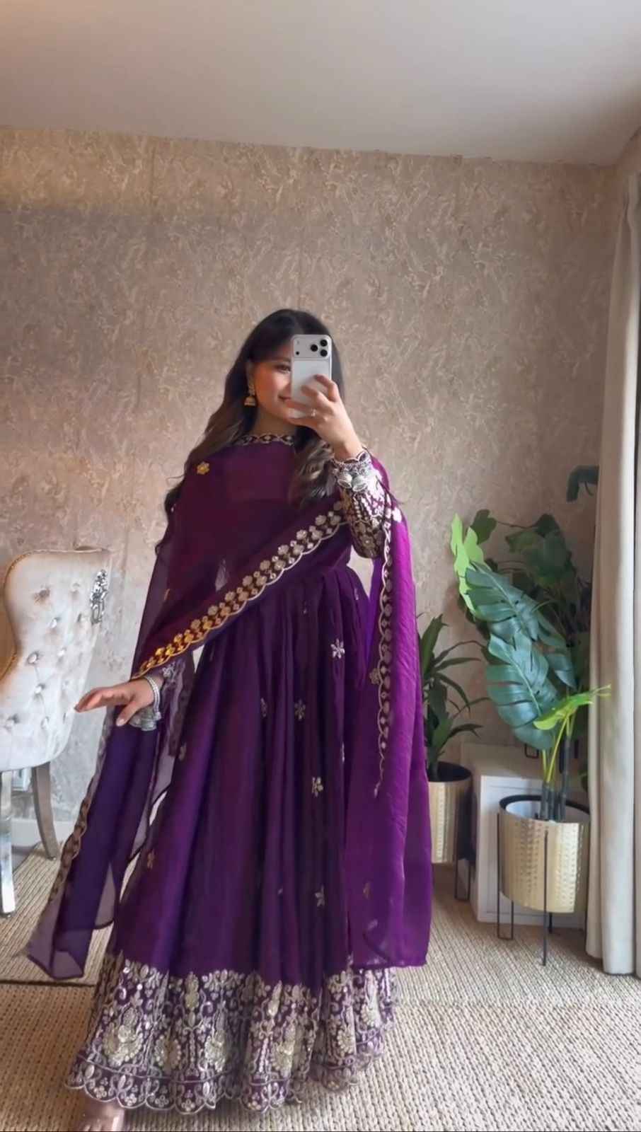 Front view of a dark purple three piece traditional outfit featuring a heavily embroidered silk anarkali gown and matching straight pants.