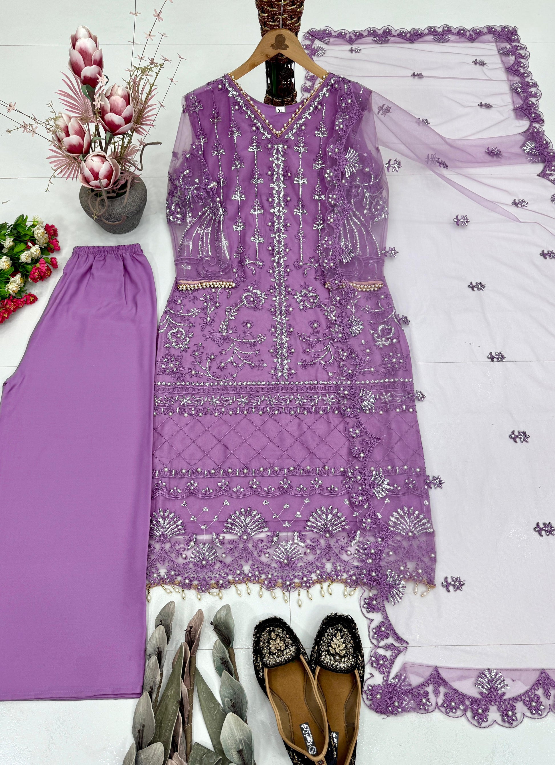 Detailed close view of shimmering pearl hand embroidery work and metallic thread decorations on a bright purple top bodice.