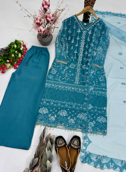 Close up view of intricate handcrafted pearl needlework patterns and premium stitching details on high quality teal blue net fabric.