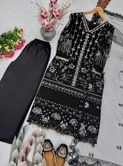 Focused shot of beautiful artisan pearl hand work and glossy chine sequence textures on deep black net fabric near the neckline.