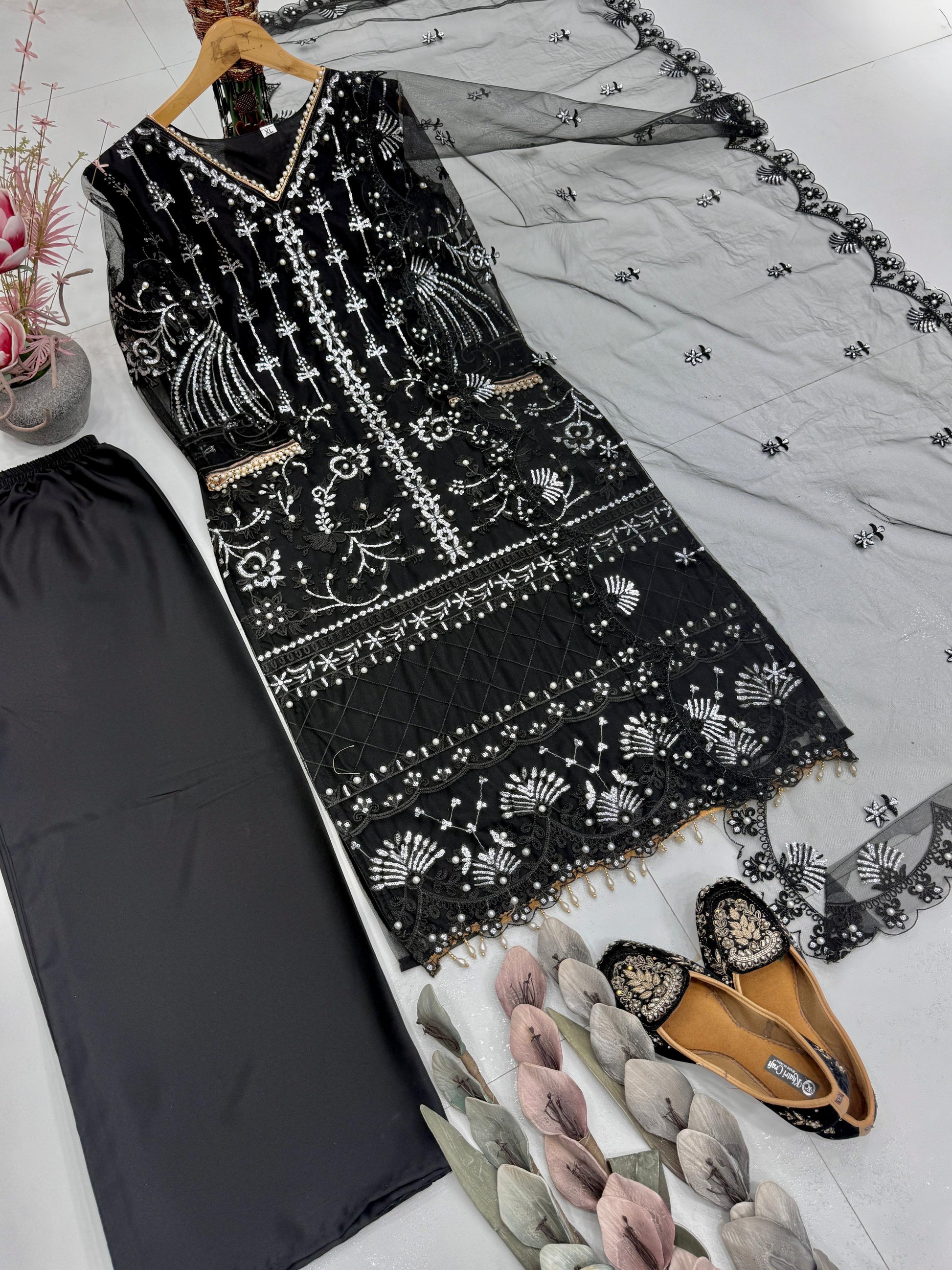 Back angle view of a black traditional ensemble showcasing the comfortable loose silhouette and smooth plain butter silk texture.