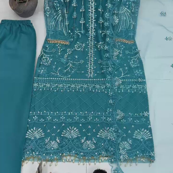 Showcase video displaying the natural fluid movement and detailed handcrafted chest pearl patterns of the teal blue soft net dress.