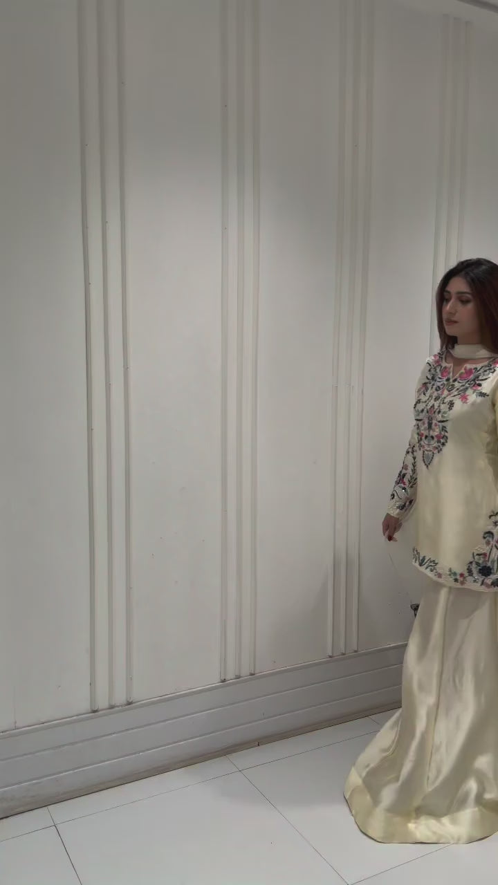 High definition retail display video highlighting the premium quality shine of the embroidery work and the smooth movement of the off white crape silk fabric under warm studio lights.