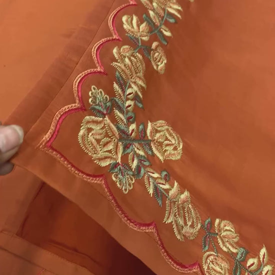 High definition retail display video highlighting the premium quality shine of embroidery work and the smooth movement of rust orange natural crepe silk material.