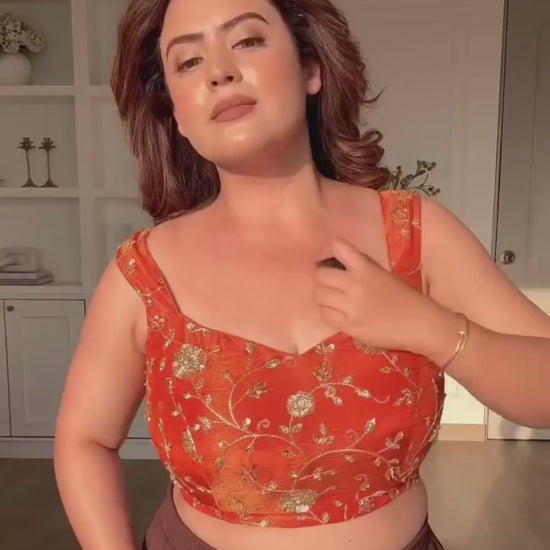 High definition retail display video highlighting the brilliant sparkle of sequence embroidery and the effortless fluid movement of the orange draped saree.